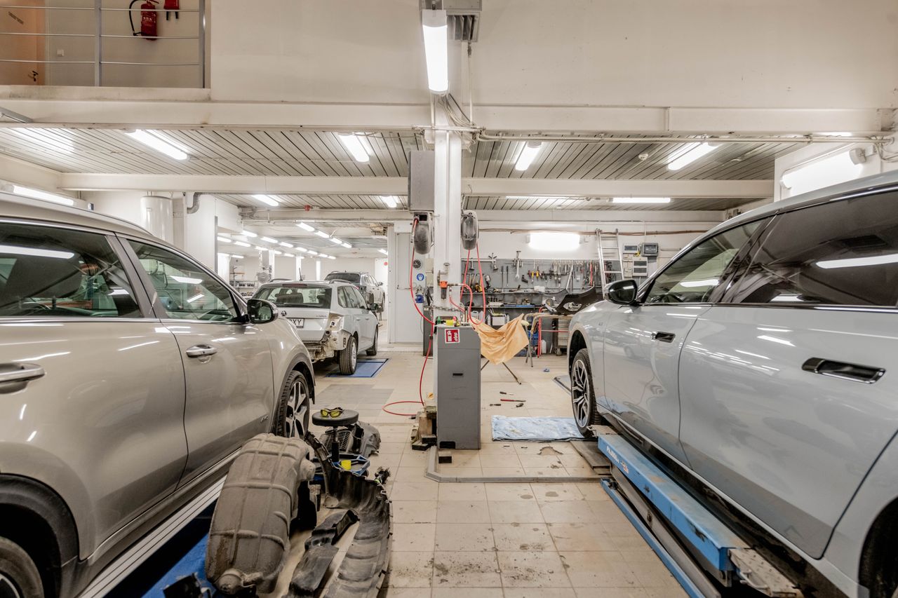 services-03 Interior of an automotive repair shop with cars undergoing maintenance and servicing.